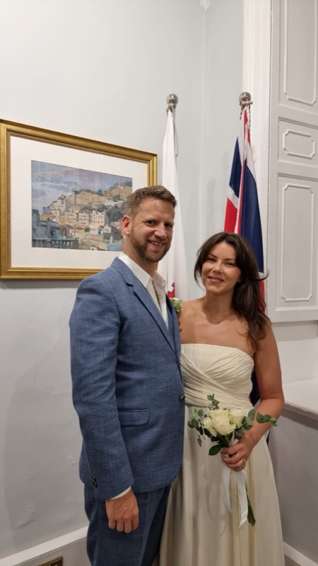 Couple at Gibraltar City Hall with Gibraltar and Union Jack flags behind them